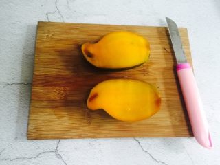 5、芒果香蕉奶昔,芒果对半切开