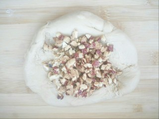 8、#甜味#红糖红枣核桃面包,再扒开面团放入红枣核桃碎揉匀