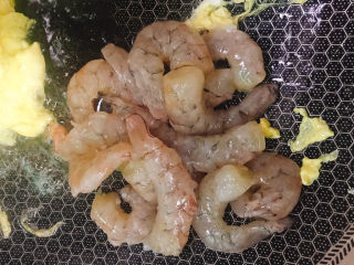 8、菠萝虾仁炒饭,将鸡蛋推到锅边，放入虾仁。