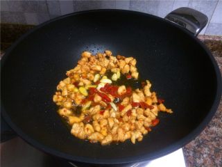 8、翡翠鸡丁,放入大蒜和枸杞翻炒10秒。