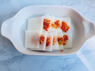 3、暖胃剁椒辣蒸萝卜汤,把剁辣椒夹在萝卜中间,蒸的时候可以更好的融入萝卜中