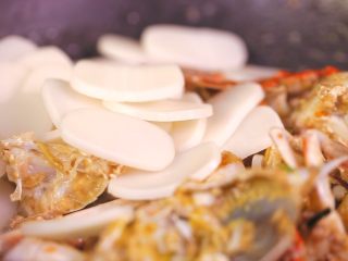 5、梭子蟹年糕,炒到螃蟹发红后，倒入耗油，料酒，翻炒炒匀后加入年糕片继续翻炒（注意年糕片要提前泡水半小时，否则炒出来太硬）