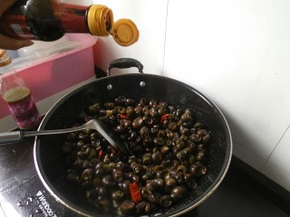 10、香辣螺蛳,接着在倒入适量的生抽、醋、白酒。在接着翻炒