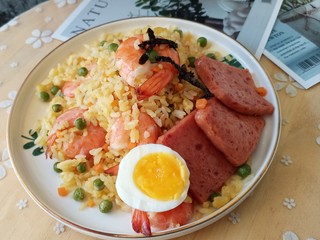 18、耳光炒饭,把炒饭盛入盘中，放上半个煮好的鸡蛋和午餐肉