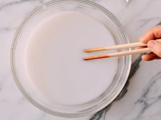 4、东北锅包肉,在碗里把马铃薯淀粉溶解于一杯半的水里,搅拌至完全溶解。放置到马铃薯淀粉完全沉淀到底部。