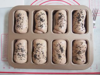 13、黑麦红枣核桃卷,表面刷上一层蛋液，撒上适量黑芝麻做装饰。烤箱预热至160度，中层上下火，20分钟左右观察表面上色即可。