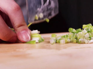 6、土豆饼的家常做法，吃起来特别过瘾,趁着蒸土豆的功夫，将葱切成葱花备用。