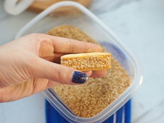 12、南瓜夹心苏打饼,再轻轻按压侧面,让白芝麻与面团更贴合。