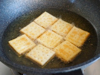 18、南瓜夹心苏打饼,沿着锅边缓缓放入夹心饼干,全程保持小火慢炸,注意翻面。炸到饼干浮起,表面金黄,沥油出锅。