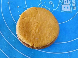 8、南瓜饼,取一块饼干放在下面，取一块南瓜面团按扁放在饼干上