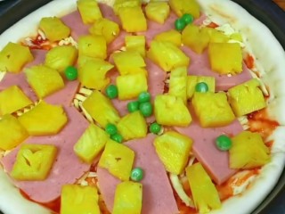 11、菠萝披萨,再放入切好的菠萝块儿和青豆。