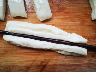 12、美味放心油条,每两条面皮上下码在一起，然后用筷子在中间压一下，目的是让两条面皮中间粘在一起