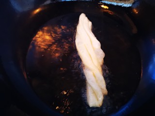 13、美味放心油条,油锅烧至七成热后放入压好的面皮炸制