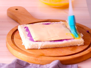 10、紫薯芝士吐司卷,再放上一张芝士片，边角刷上蛋液