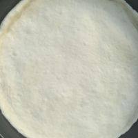 5、火腿培根披萨,发酵好的面团排气后盖保鲜膜松弛10分钟，然后擀成和披萨盘同样大的圆饼状，披萨盘里刷油，把披萨饼放入披萨盘，醒发15分钟