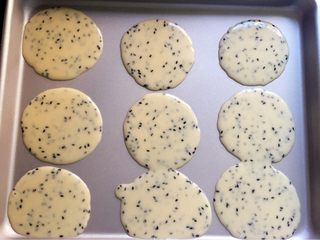 10、芝麻鸡蛋薄脆饼,用勺子取鸡蛋面糊,小勺子一勺即可,把面糊倒在烤盘上。(我的是不粘烤盘,你如果不是这种烤盘,需垫油纸哦。)