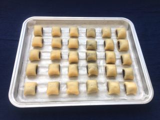 14、玫瑰豆沙一口酥,烤盘垫上油纸,整齐摆放在烤盘上。