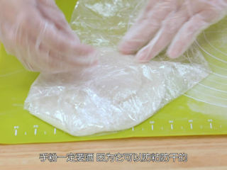 8、雪媚娘大福,每擀好一张面皮之后在表面抹上一点手粉防粘,然后叠在一起,放在保鲜膜上面,再用保鲜膜包好,防止皮干掉,皮干掉就会变硬,包不起来了,手粉一定要撒,因为它可以防粘和防干哦,包之前把所有面皮都擀好备用,因为待会要包淡奶油,淡奶油比较容易化