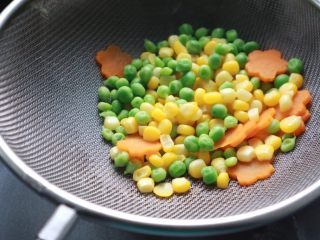 2、培根火腿鲜虾披萨,玉米粒、青豆、胡萝卜片焯水煮至半熟，然后沥干水分备用