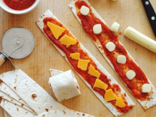 2、比萨卷饼,在比萨饼条上面先抹上比萨饼酱，再放上车打芝士，撒上百里香。然后卷起来。