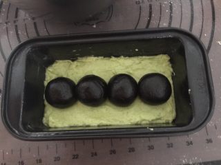 14、奥利奥牛油果磅蛋糕,接着排入4个黑色小圆球，也可以直接搓成圆柱体，我的面团太干容易裂开，所以分成4个小圆球（其实最好是搓成完整一个圆柱体）