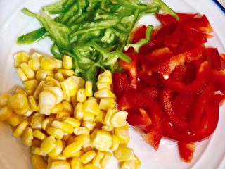 2、火腿披萨（手抓饼版）,把青红灯笼椒切成丝，甜玉米解冻。