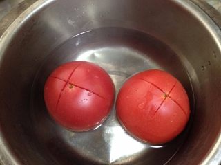 2、自制披萨酱,番茄顶部切十字花刀，泡入开水中一分钟剥去外皮