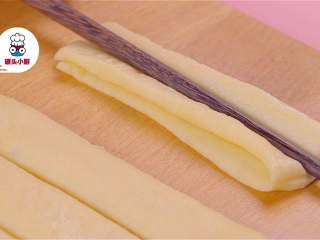 4、无添加安心油条,将面团切成长条，取两条叠在一起，用筷子在中间压实