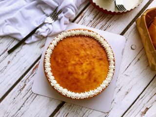 16、鱼之恋芝士蛋糕,淡奶油打至9分硬,装入装了花型裱花嘴的裱花袋里,裱出一圈奶油花。