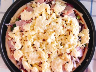 14、芝士培根披萨,再铺上一层芝士碎。