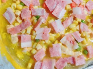 3、自制版披萨,烤完拿出来再撒上玉米粒青豆粒，把剩余鸡蛋液全部倒在上面，再放一层培根（切片）。