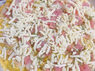 5、自制版披萨,取出烤盘撒一层马苏里拉芝士碎，再继续放入烤箱烤至芝士碎融化即可。