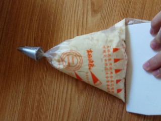 14、曲奇饼干,装进裱花袋后用刮板把面糊刮进去