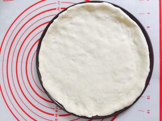 9、简单好吃的培根虾仁披萨????,将面皮铺进烤盘里，边缘部分用手轻轻整理一下！