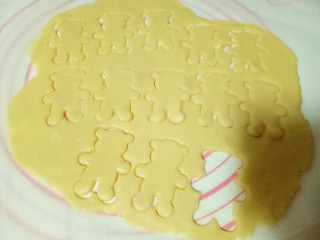 9、小熊抱杏仁饼干,全部压完后，小心得取下小熊，放在铺好油纸的烤盘中，边上多余下来的面皮在揉成团，重新做步骤，依次做完。