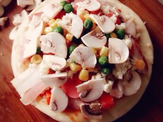 2、Mini披萨,饼皮刷一层薄油，接着刷披萨酱，洒上奶酪，铺上培根、香肠，再撒上奶酪，铺蔬菜