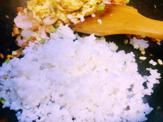 25、虾仁什锦蛋炒饭,接下来炒好的26全部放在炒好的鸡蛋锅的那边，倒入蟹田大米饭（大米饭均可）翻炒热散籽