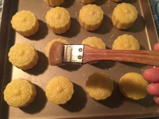 31、流心奶黄月饼,提前把1个蛋黄兑1茶匙水搅拌均匀，最好过筛一两次，月饼烤完第一次定型后拿出来再刷一层薄薄的蛋液，刷蛋液后再放回烤箱里，转至180烤5分钟