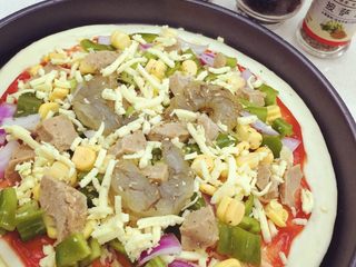 2、鲜虾牛肉披萨：简易版,虾仁可事先用酱汁腌一下调味 再将青椒 玉米 洋葱 牛肉粒 虾仁均匀摆放在饼底上 在表面撒满马苏里拉芝士 最后撒上现磨黑胡椒与披萨草调味 喜欢吃芝士的宝宝可以多撒一些 拉丝效果会更强