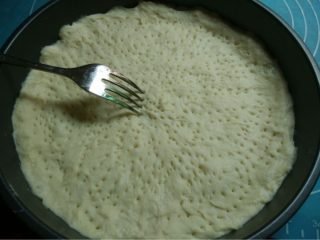 2、虾鲜拼QQ肠披萨,如图将面团放入披萨盘里按中间平四周稍厚，再用叉子叉些小孔利于排气