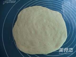 3、自制披萨,将发酵好的面团取出,压扁排气,再擀成圆片