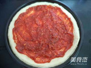 8、自制披萨,将披萨酱均匀的抹在披萨坯上