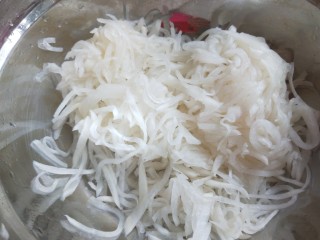 10、白萝卜香辣凉拌菜   新文美食,这会的白萝卜丝淹出水来了，放入沙布里，挤出水分。