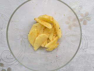 3、培根薯角薄底披萨,马铃薯切成小块，加入椒盐粉、孜然粉和橄榄油拌均匀。