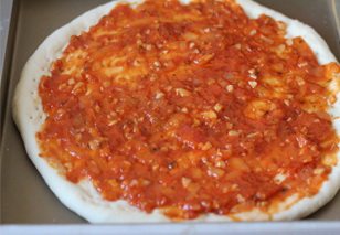 17、金枪鱼披萨,醒发好的披萨面皮抹上一层披萨酱。