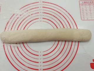 7、自制健康小油条,揉面垫洒点手粉,把面团滚成圆条状;