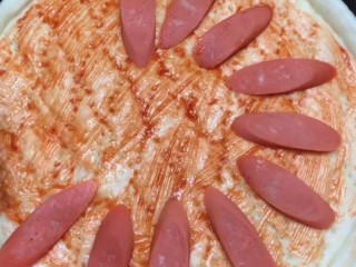 8、培根火腿披萨,醒发后的面饼是之前面饼的两倍厚，在面饼上刷上一层番茄酱，在放上一层火腿。