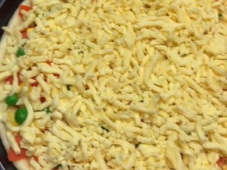 11、培根火腿披萨,铺平芝士，烤箱提前预热，上下火160°烤15分钟。