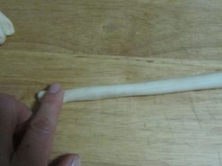 7、酥脆麻花,将饧好的拇指粗的长条再搓成细长条,在搓的时候注意左右手向相反的方向搓;(你也可以搓好长条后按住一端,将一端向一个方向滚动);