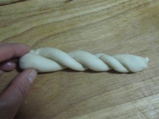 8、酥脆麻花,将两端拧起, 它们会自然的绞在一起(你再将下端部分整理一下);